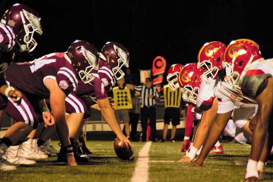 College football players line up at the line of scrimmage at night